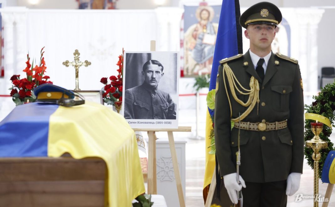 Труна з прапором України, портрет Євгена Коновальця та військовий почесний караул