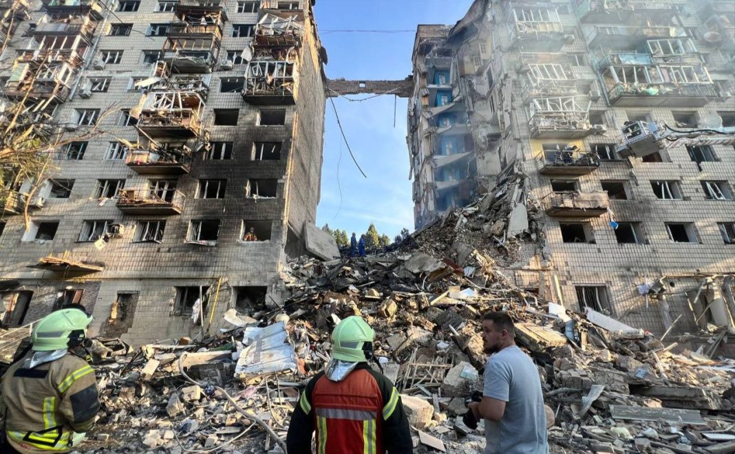 Пошкоджений багатоповерховий будинок після російського обстрілу, рятувальники розбирають завали
