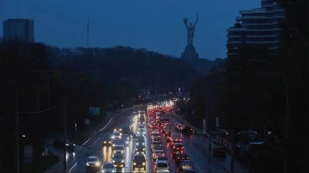 Автомобільний затор на одній із магістралей Києва у сутінках на тлі монумента «Батьківщина-Мати».